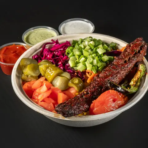 Beef Adana kebab bowl with rice, fresh toppings and sauces